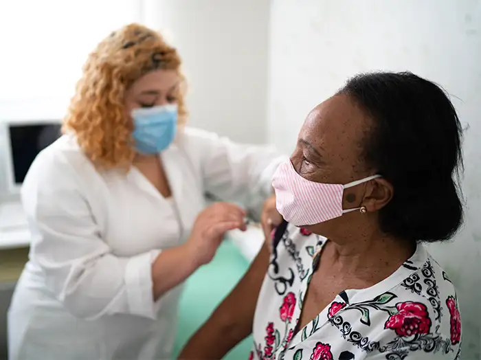 Photo of receiving a vaccine shot from a female nurse. Photo of receiving a vaccine shot from a female nurse.